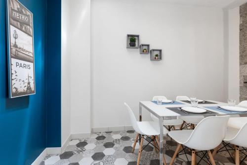 une salle à manger avec une table blanche et des chaises blanches dans l'établissement GuestReady - Nice apartment for 6 in Paris, à Paris