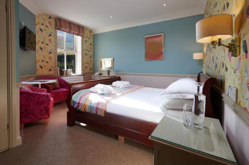 una camera d'albergo con letto e sedia di The Devonshire Fell Hotel a Burnsall