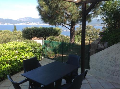 - une table et des chaises sur une terrasse avec vue sur l'eau dans l'établissement Porticcio, à Porticcio