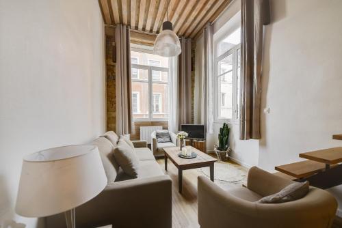 un salon avec un canapé, des chaises et une table dans l'établissement GuestReady - Magnificent duplex canut hypercentre, à Lyon