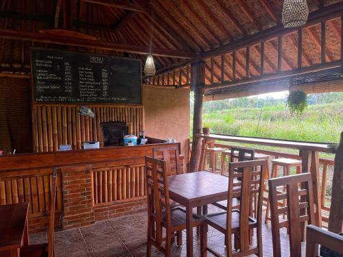 Un bar con una mesa y sillas en un restaurante. en Gempinis Coffee Shop and Villa, en Blimbing