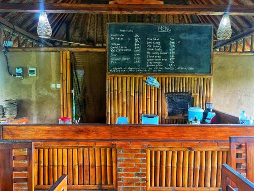 Un bar en un restaurante con una pizarra. en Gempinis Coffee Shop and Villa, en Blimbing
