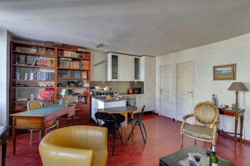 una cucina e un soggiorno con tavolo e sedie di GuestReady - Amazing Le Marais Flat - 2 mins to Hôtel de Ville a Parigi