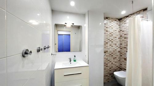 un bagno con lavandino, specchio e WC di THE BEST OCEAN VIEW a Playa de las Americas