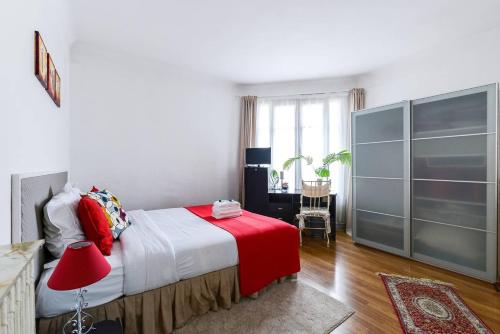 a bedroom with a bed and a desk with a red lamp at GuestReady - Beautiful Apt - 5 mins to Chinatown in Paris