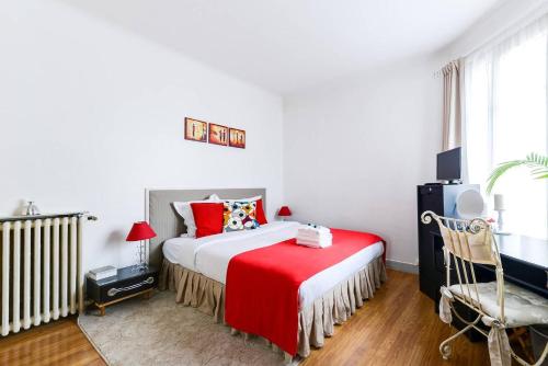 a bedroom with a bed with a red blanket at GuestReady - Bel Apt à 5 minutes de Chinatown in Paris