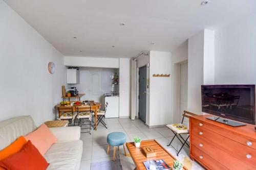 ein Wohnzimmer mit einem Sofa und einem Tisch in der Unterkunft GuestReady - Charming Flat - 6 mins to Gare Du Nord Metro in Paris