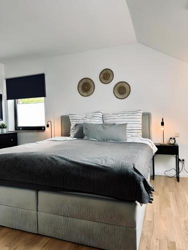a white bedroom with a large bed and a window at FeWo Burgblick Sonnenterrasse & Burgblick in Bad Bentheim