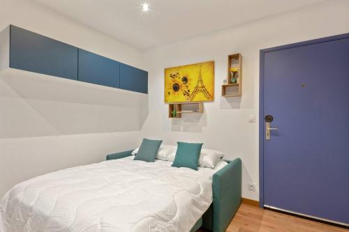 - une chambre avec un grand lit blanc et des armoires bleues dans l'établissement GuestReady-Charming Studio 15 mins to Grand Palais, à Paris