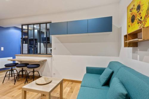 un salon avec un canapé bleu et une cuisine dans l'établissement GuestReady-Charming Studio 15 mins to Grand Palais, à Paris