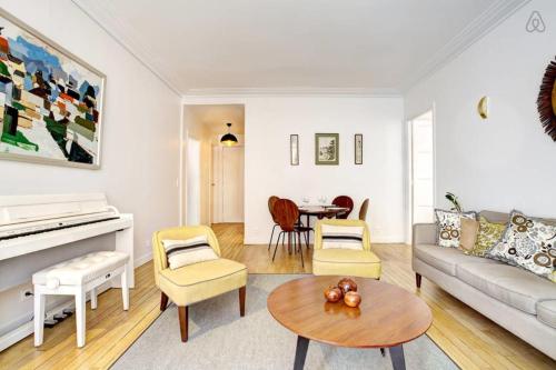 a living room with a couch and a piano at GuestReady - Bright Flat at Porte d'Auteuil Metro in Paris