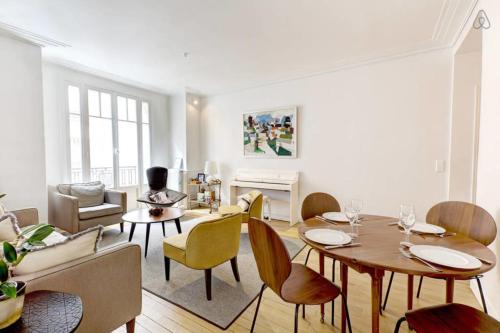 a living room with a table and chairs at GuestReady - Bright Flat at Porte d'Auteuil Metro in Paris