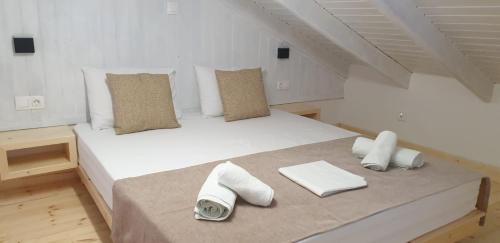 a bedroom with a large white bed with towels on it at Apart-Hotel Llazari in Himare