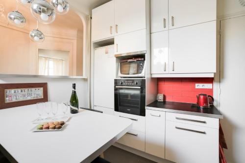 une cuisine avec des placards blancs et un comptoir blanc dans l'établissement GuestReady - Amazing 2BR Flat near Passy Village, à Paris