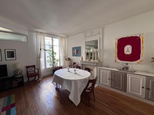 uma sala de jantar com uma mesa com uma toalha de mesa branca em GuestReady - Amazing 2BR Flat near Passy Village em Paris