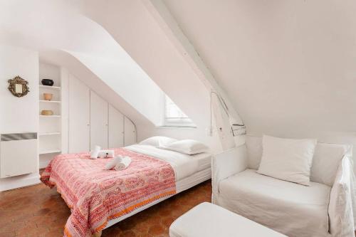 une chambre blanche avec un lit et une chaise dans l'établissement GuestReady - Confort et charme au cœur de Paris, à Paris