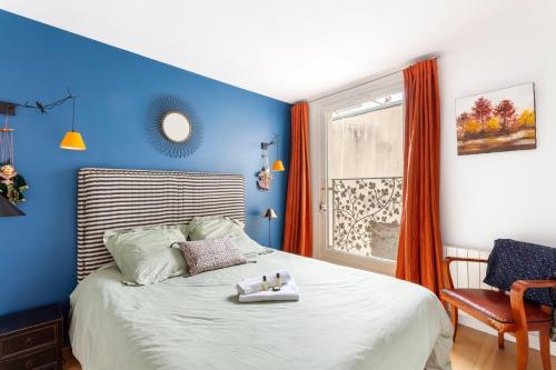 - une chambre bleue avec un lit et une chaise dans l'établissement GuestReady - Spacious apartment in the heart of the Marais, à Paris