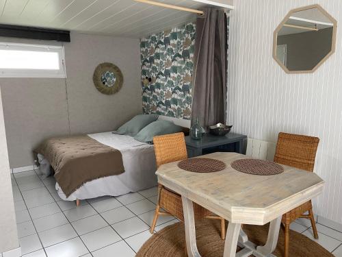 une chambre avec un lit, une table et des chaises dans l'établissement Maison Studio La Chaume de 20 m2, à Les Sables-dʼOlonne