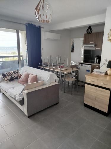 un salon avec un canapé et une cuisine dans l'établissement Sète : charmant T3 entre l'étang et les plages, à Sète