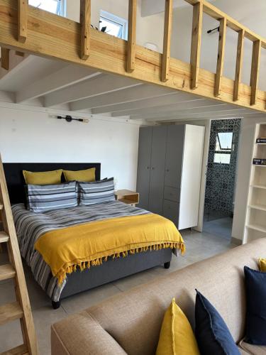 - une chambre avec un lit doté d'un couvre-lit jaune dans l'établissement Modern apartments downtown, à Plettenberg Bay