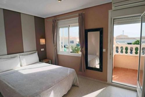 a bedroom with a bed and a large window at Casa,Solarium,Barbacoa,Piscina in Gran Alacant