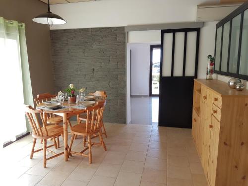 une salle à manger avec une table et des chaises en bois dans l'établissement Porticcio, à Porticcio