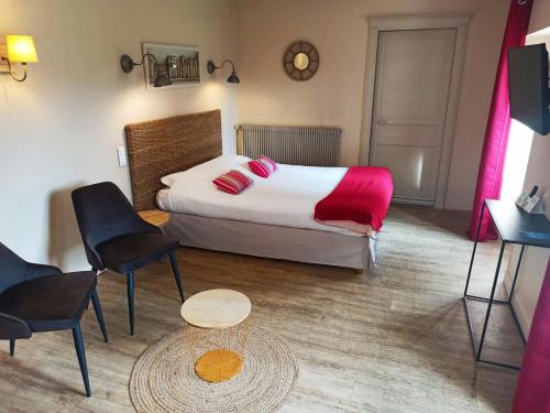 a bedroom with a bed and a table and chairs at Logis Hotel Le Prince Noir in Sérignac-sur-Garonne