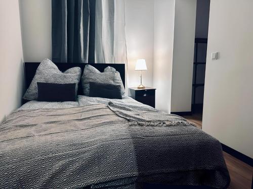 a bedroom with a bed with a black and gray comforter at FeWo Kupferkrug Historisch & Zentral in Nordhorn