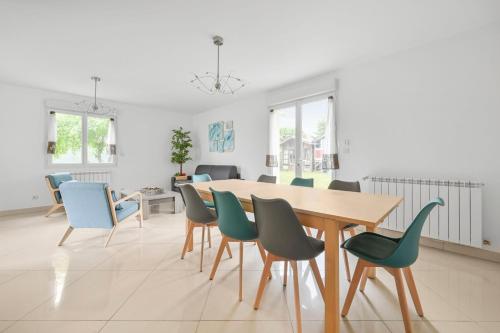une salle à manger avec une table et des chaises dans l'établissement La Coquette - Maison 10p - Paris & Disney, à Champigny-sur-Marne