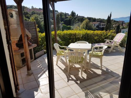 une table et des chaises sur une terrasse avec vue dans l'établissement Porticcio, à Porticcio