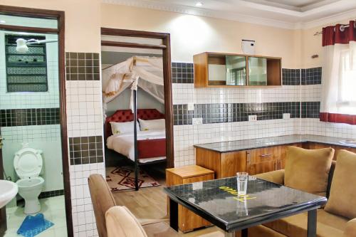 a room with a table and a bathroom with a bed at Toque Hotel in Nairobi