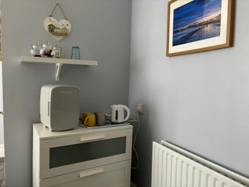 um quarto com uma cómoda e um micro-ondas em Calm sea guesthouse em Weymouth