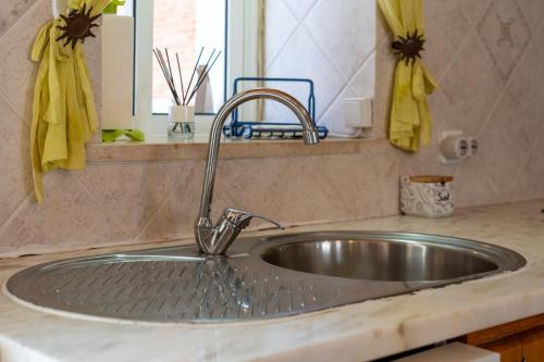 a stainless steel sink in a kitchen with a mirror at Casa O Cantinho Algarvio in Odeceixe