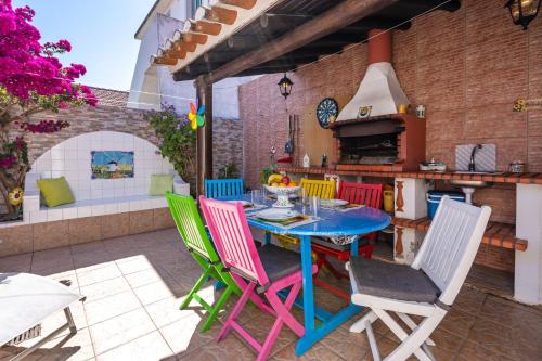 a patio with a table with colorful chairs and an oven at Casa O Cantinho Algarvio in Odeceixe