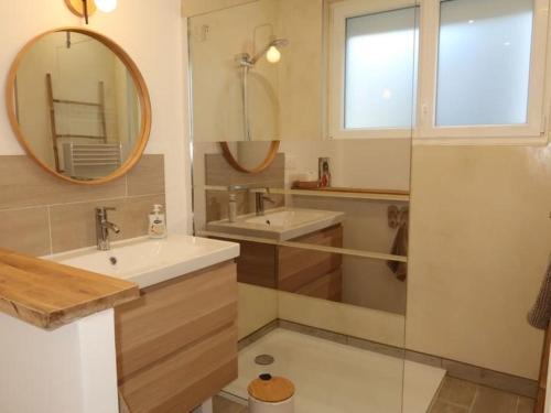 une salle de bain avec un lavabo, un miroir et une douche dans l'établissement Villa Ty PY : Charme moderne et tranquillité, à Fouesnant