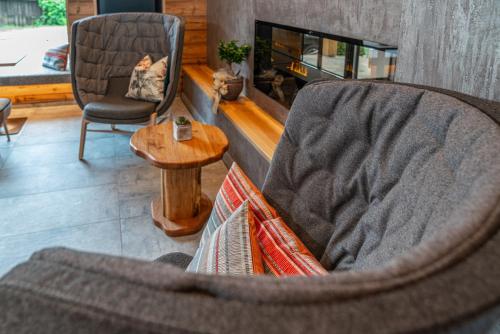 a living room with a chair and a table and a fireplace at Stadtvilla Schladming Boutiquehotel in Schladming