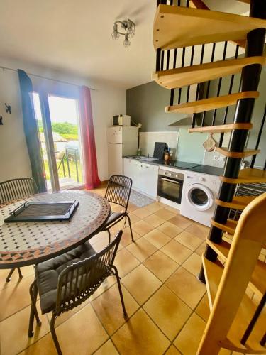 une cuisine et une salle à manger avec une table et des chaises dans l'établissement Gite 4p, 2 chambres, jardin, piscine à partager, à Alba-la-Romaine