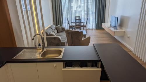 a kitchen with a sink and a living room with a couch at Ferienwohnung Azur Paradies Nordzypern in Küçükerenköy