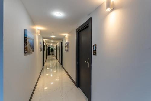 a hallway with white walls and a black door at Yusufhan Suites in Trabzon