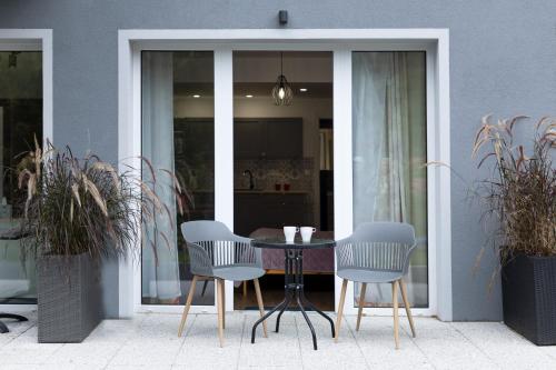 a table and chairs in front of a building at Apartamenty Wczasowa - z widokiem na góry, parkingiem, rowerownią in Kudowa-Zdrój