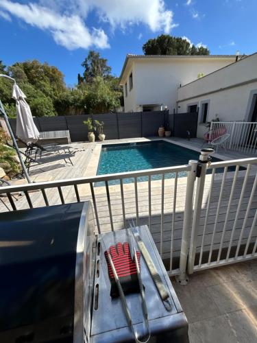 - une piscine avec une chaise rouge à côté dans l'établissement Maison avec 2 couchages piscine privative, à Ajaccio