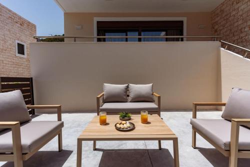a patio with two chairs and a table with two glasses of orange juice at Brikis Villa 2 - With Private Pool in Balíon