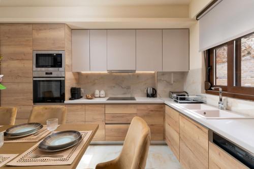 a kitchen with white cabinets and a table and chairs at Brikis Villa 2 - With Private Pool in Balíon