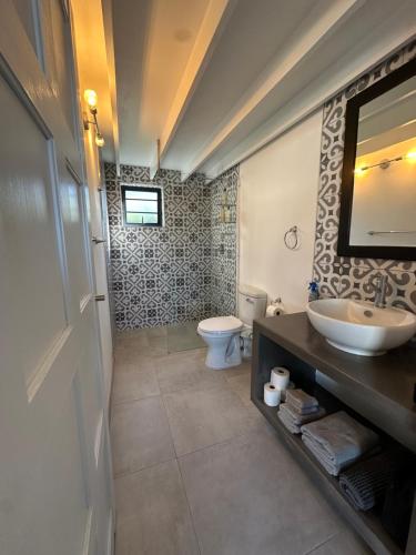 uma casa de banho com um lavatório e um WC em Modern apartments downtown em Plettenberg Bay
