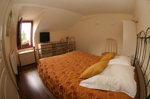 a bedroom with a bed and a television in it at L'Amphitryon in Coudray