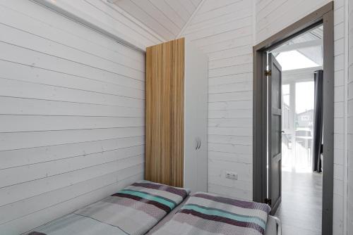 a bed in the corner of a room with a window at Audronašų Vilos in Šventoji
