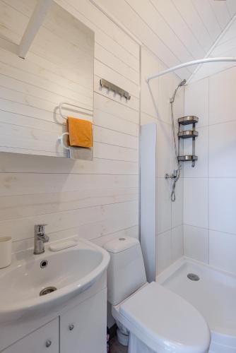 a white bathroom with a sink and a toilet at Audronašų Vilos in Šventoji