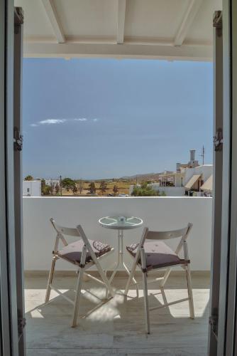 a table and two chairs and a glass table and chairs at Rose House and Apartments in Andiparos