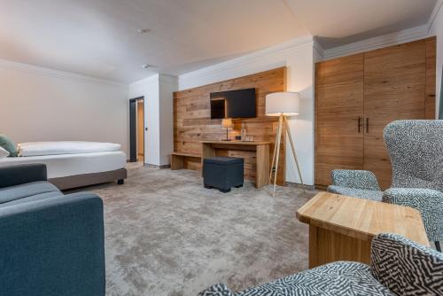a room with a bed and a desk with a tv at Stadtvilla Schladming Boutiquehotel in Schladming