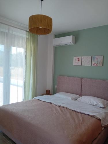 a bedroom with a large bed and a window at Ξενώνας Προσφοριον in Archipolis